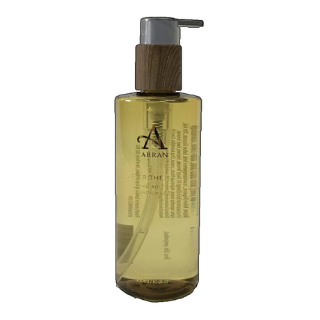 A transparent 300ml bottle of After The Rain Hand Wash with a pump dispenser and a wooden collar. The label showcases the brand name and text, while the liquid inside has a light yellow hue.