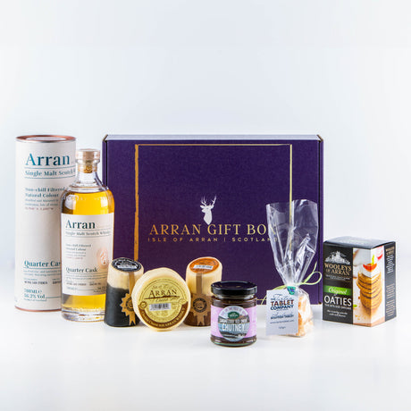 Product Name: Deluxe Whisky Lover Gift Box with Arran Quarter Cask Finish Single Malt Scotch - Includes cheese, oatcakes, chutney, and shortbread. Presented in a dark purple box with gold lettering: "Arran Gift Box, Isle of Arran, Scotland.