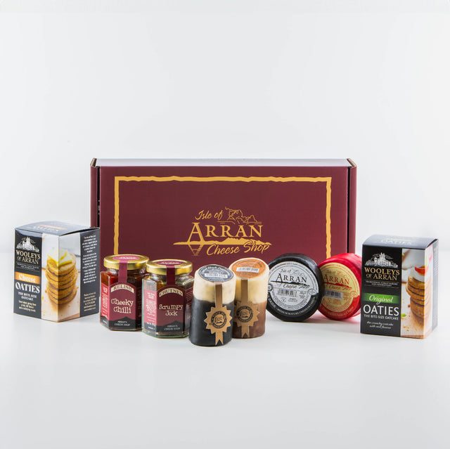 Explore a delightful array of Arran cheddars and gourmet foods from the Isle of Arran Cheese Shop. This exquisite collection includes a variety of cheeses, jars of chutney, and boxes of oatcakes, all elegantly showcased in front of our signature branded gift box—a perfect indulgence for any Cheese Lover Hamper enthusiast.