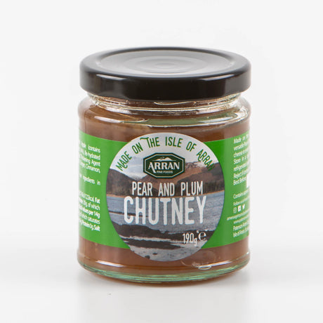 A jar of Pear and Plum Chutney from Arran Fine Foods features a green label depicting the picturesque Isle of Arran. This 190g jar is filled with rich, brown chutney, ideal for holiday feasts.