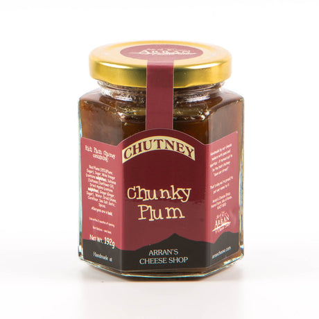 Arran's Cheese Shop presents "Chunky Plum" chutney in a hexagonal glass jar adorned with a gold lid, showcasing local island produce. The burgundy label is accented with white and yellow text, and the net weight is 192g.