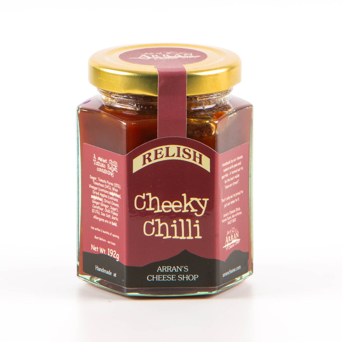 A delightful "Cheeky Chilli" relish is housed in a hexagonal glass jar with a gold lid, sourced from Arran's Cheese Shop as local produce. Its origin is elegantly displayed on a maroon label with white text, and the net weight of the relish is 192g.