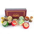 A 10 Box Deal of Arran Cheeses from the Isle of Arran Cheese Shop, beautifully arranged in front of an arran cheese shop gift box. The assortment includes round cheeses with vibrant wax coatings in red, green, black, and more, as well as several smaller cylindrical cheese packages—ideal for bulk purchasing.