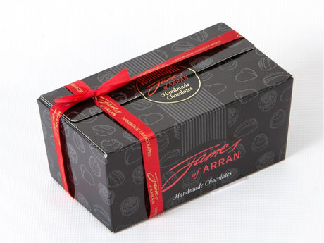 The James Chocolates 350g Assorted Box of Chocolates is elegantly presented in a black box adorned with artisanal chocolate patterns and wrapped with a red ribbon, featuring "James of Arran" prominently on the lid.