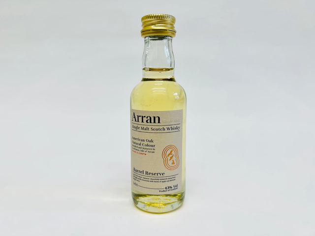 The Arran Barrel Reserve Single Malt Whisky Miniature 5cl showcases a golden cap, with its transparent glass revealing a pale amber liquid that is sure to entice any whisky lover. The label prominently features the terms "American Oak" and "Natural Colour," and it has an alcohol content of 43%.