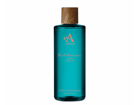 This 300ml bottle of Kildonan Bath and Shower Gel by Arran Sense of Scotland showcases a vibrant turquoise hue with a wooden cap, and its label proudly highlights "Orris & Violet Leaf," offering a fragrant journey to the serene Scottish shores.