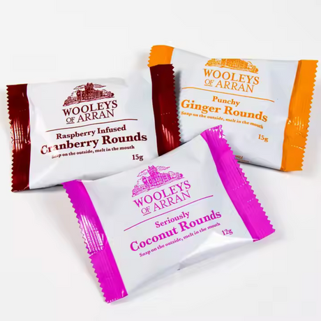 Three packets of Wooley’s of Arran oat biscuits include Raspberry Infused Cranberry Rounds, Punchy Ginger Rounds, and Seriously Coconut Rounds. Each packet is distinctively colored in red, orange, and purple. These selections feature the Wooleys Cranberry Biscuits 2 pack.