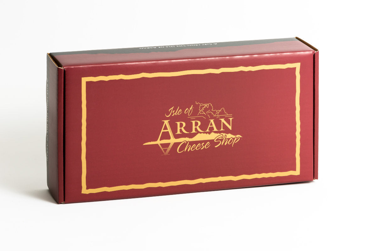 A rectangular maroon "A Classic Arran Gift Box" featuring a stylized island outline and adorned with the words "Isle of Arran Cheese Shop" in gold.